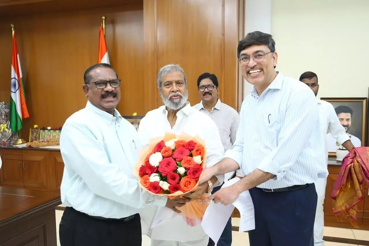 Men in an office presenting a large bouquet of roses beside national flags