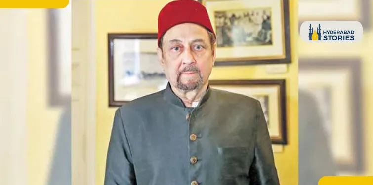 Portrait of a man in a red cap and dark jacket in front of framed pictures