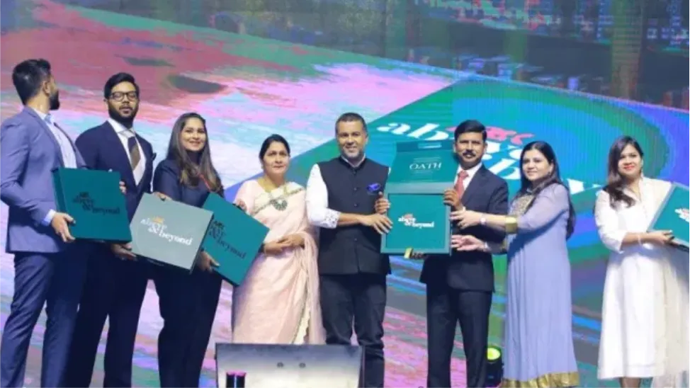 Group of people in formal dress holding presentation folders on a lit stage