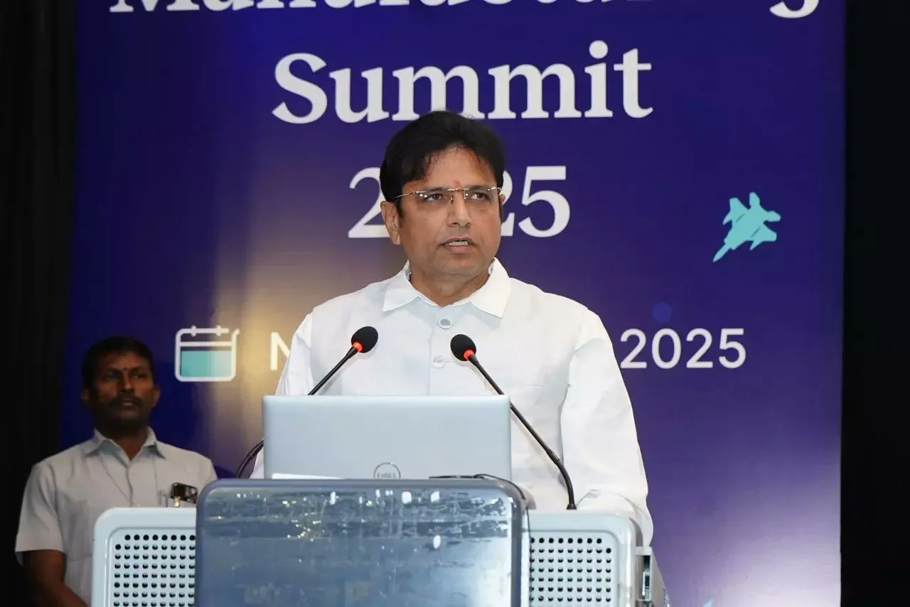 Man speaking at a lectern with microphones in front of a summit banner