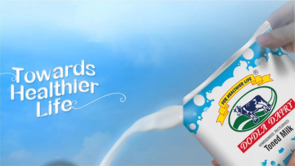 Milk pouring from a carton against a blue sky beside a tagline