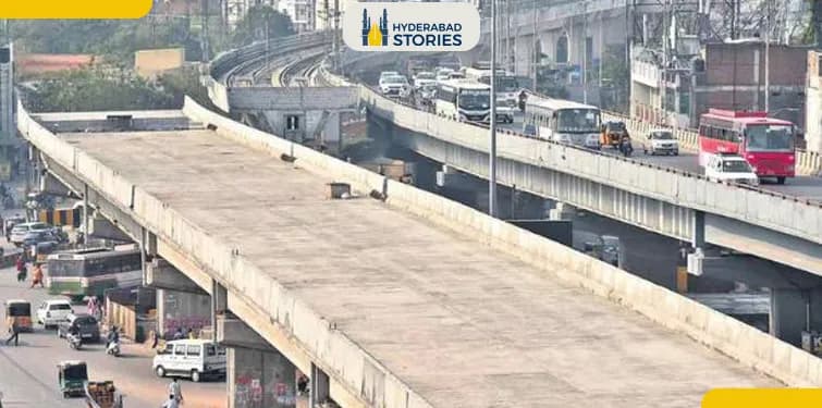 Traffic on a road beside an elevated metro viaduct in daytime