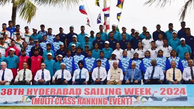 Large group photograph of a sailing squad beneath a banner