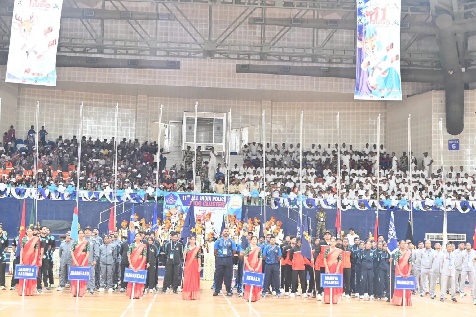 Rows of uniformed personnel assembled in an indoor arena