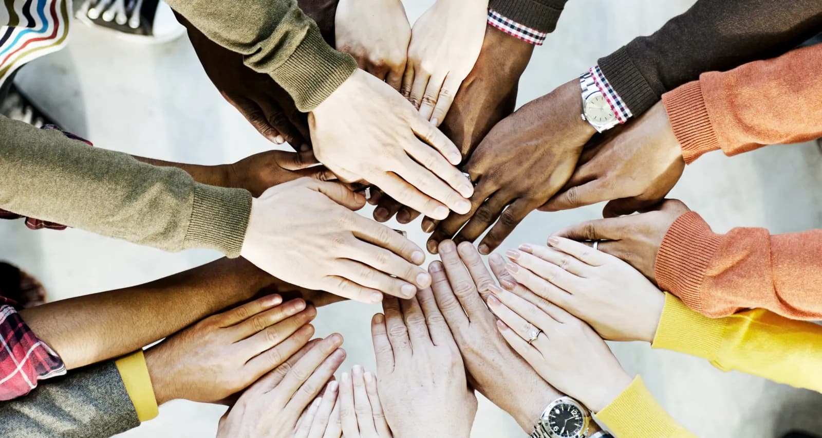 Many hands placed together in a circle