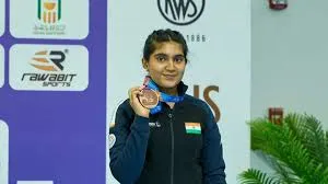 Athlete holding up a medal beside sponsor boards