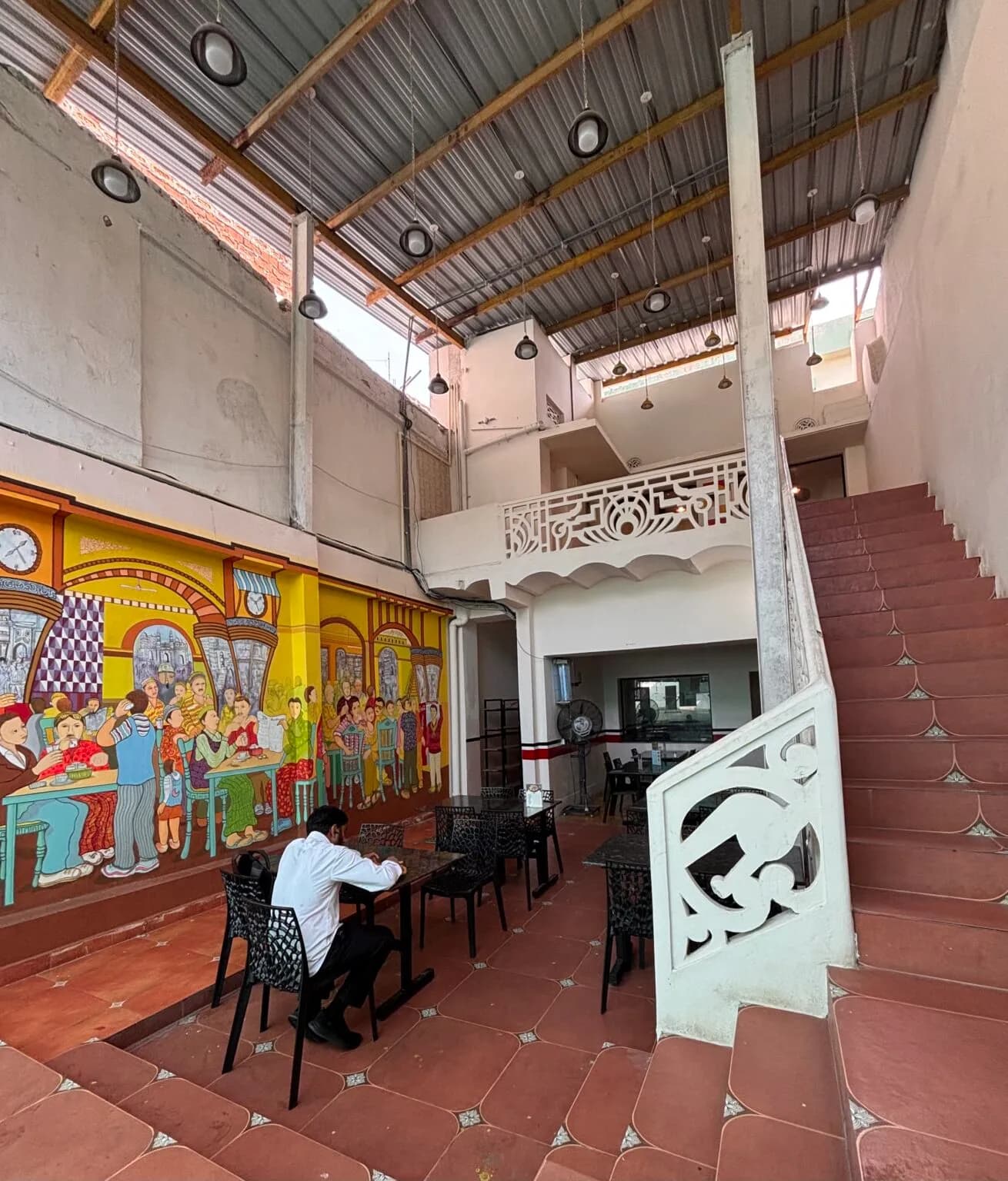 Interior of a hall with painted murals and a staircase