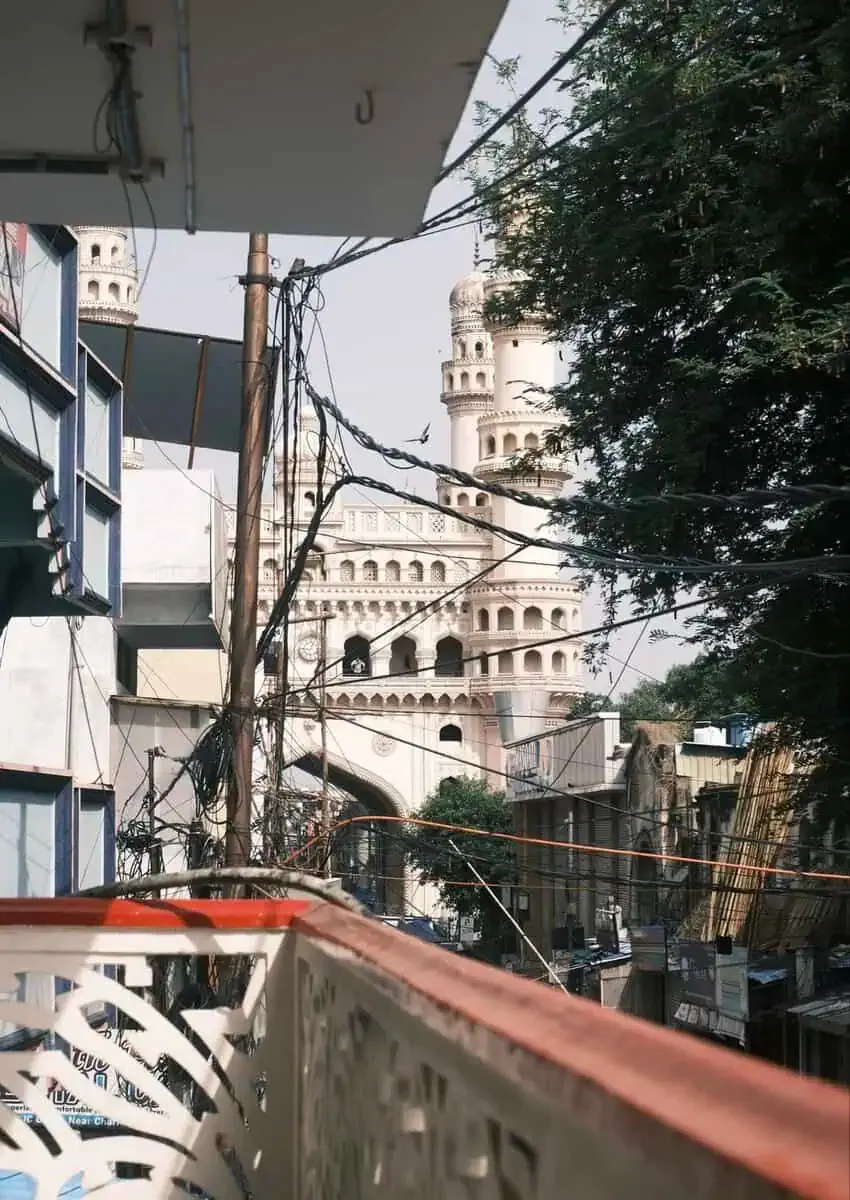 View of a domed monument between rooftops and cables