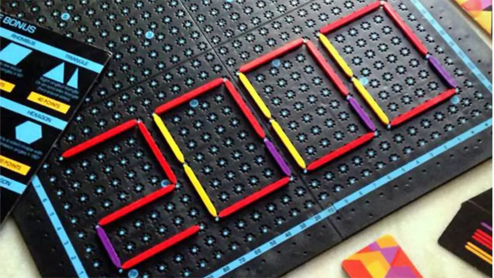 Close-up of a board game with coloured plastic pieces on a pegged grid