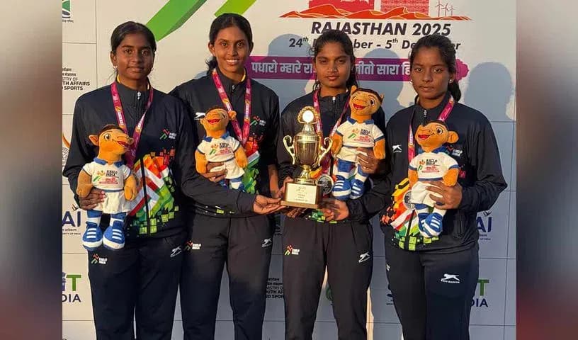 Four athletes in tracksuits holding a trophy and mascot toys
