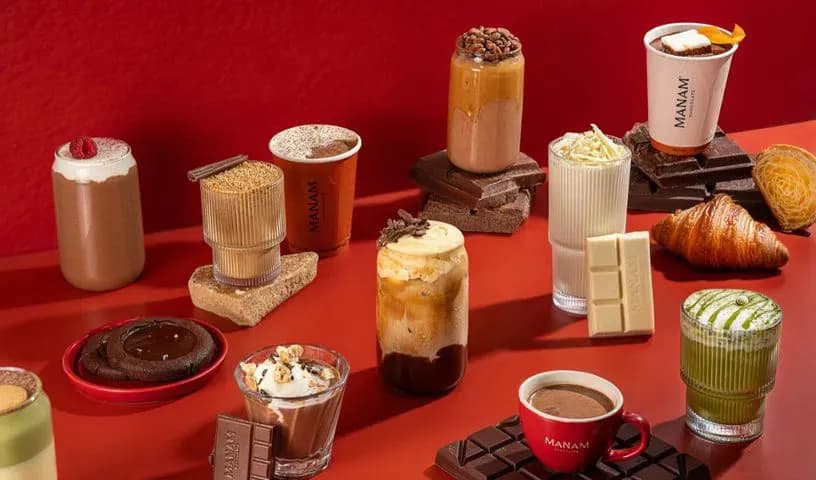 Chocolate drinks, pastries and bars arranged on a red surface