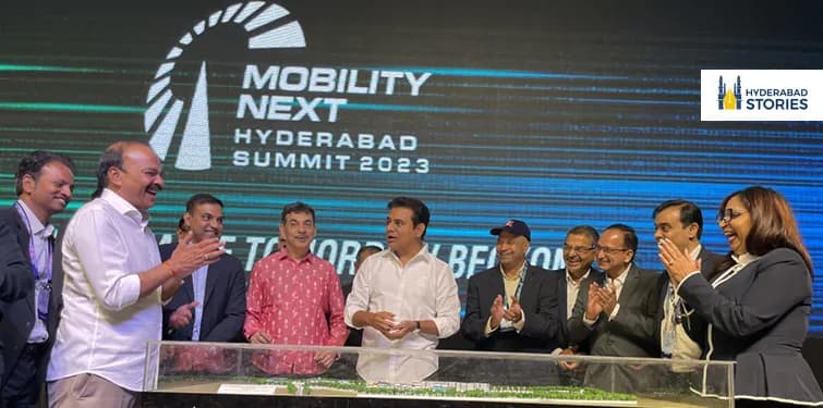 People applauding on a stage before a summit banner