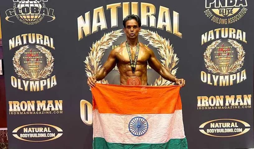 Bodybuilder holding a flag on a competition stage