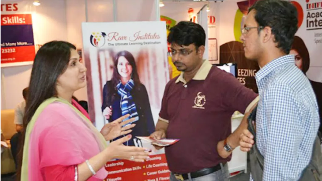 People talking at an exhibition stand with printed banners behind them