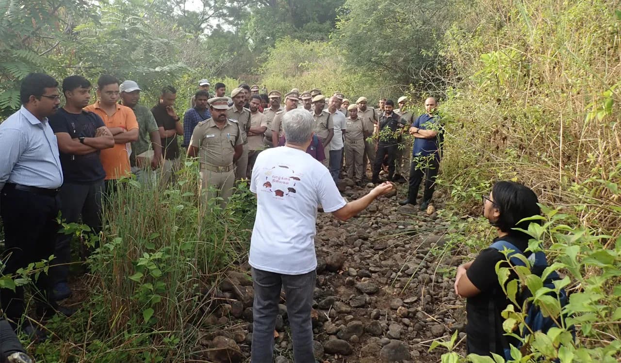 Group of officials and workers standing on rocky scrubland