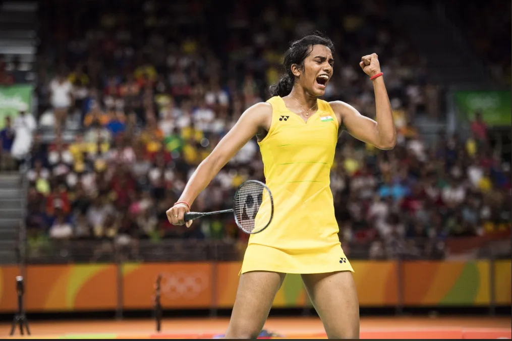 Badminton player celebrating with a clenched fist on court