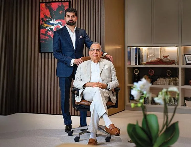 Two men posed in a wood-panelled room