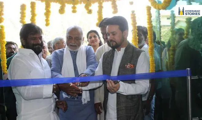 People cutting a ribbon beneath marigold garlands