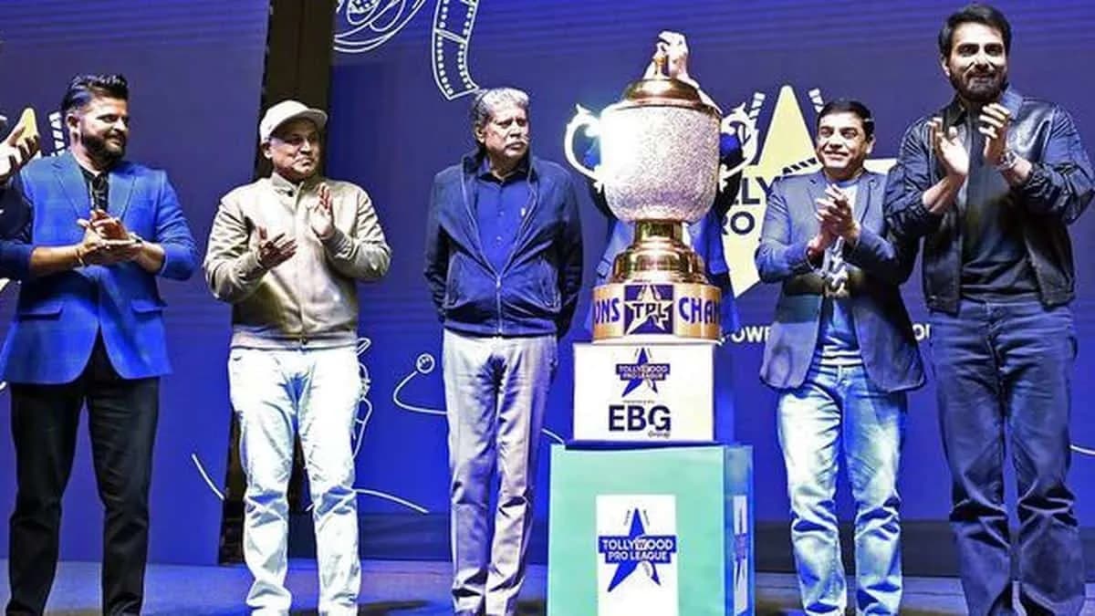 People on a stage with a large trophy