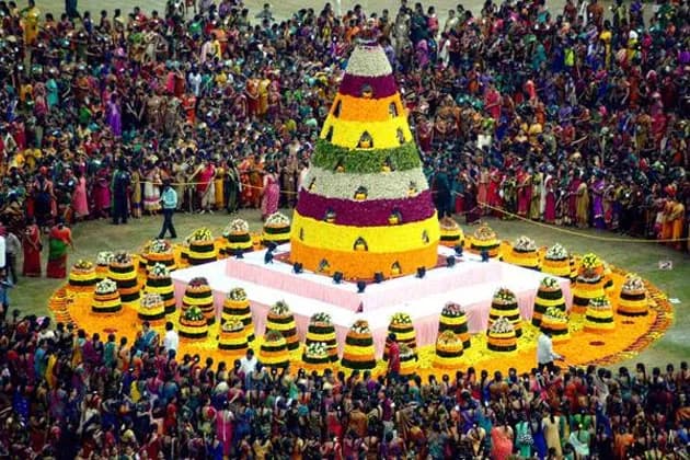 Tall tiered floral display surrounded by a large crowd