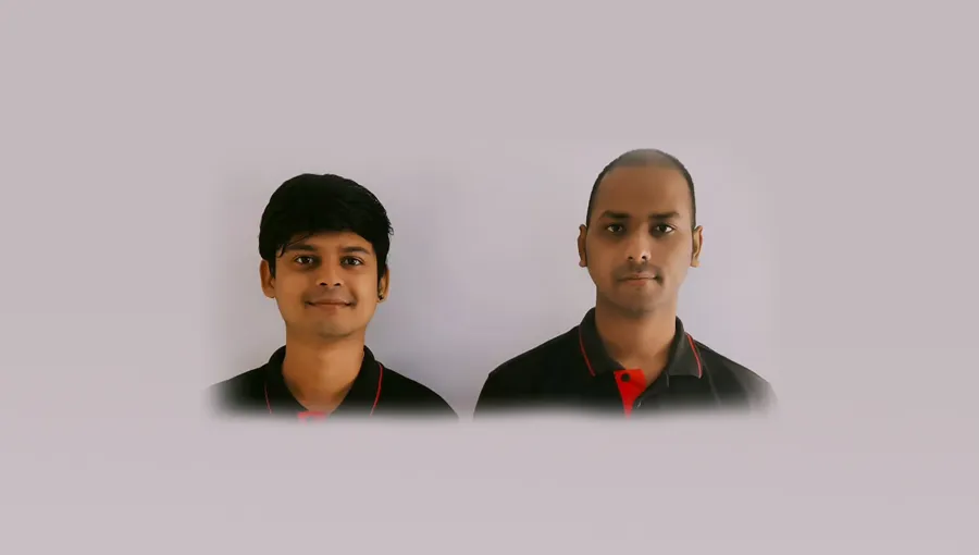 Two people in dark uniforms against a plain background