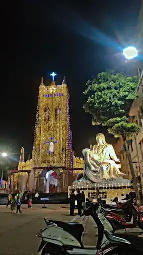 Floodlit church tower and statue at night