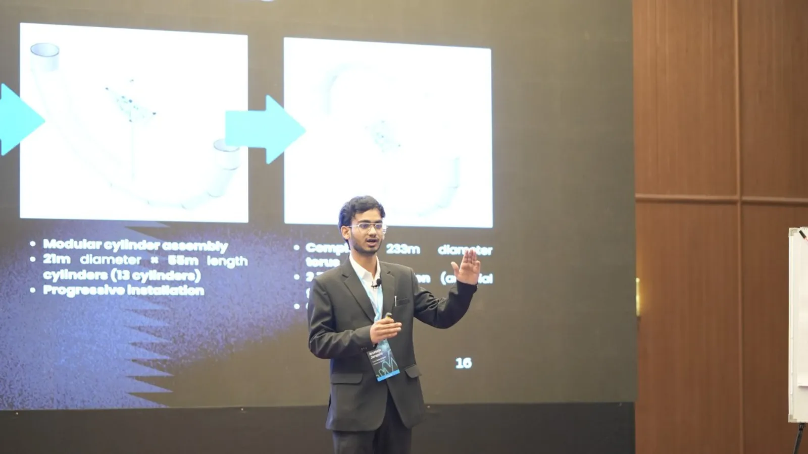 Man presenting beside a projected technical slide